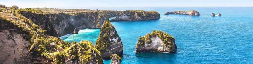 Amazing panoramic view of tropical beach, sea rocks and turquoise ocean, blue sky. Atuh beach, Nusa Penida island